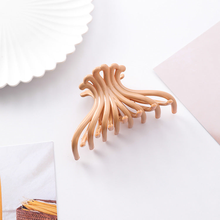 Orange apricot wave hair claw clip on a white styled surface