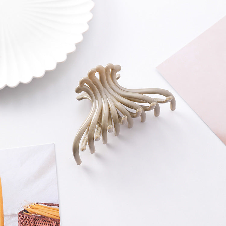 Khaki tan wave hair claw clip on a white styled surface
