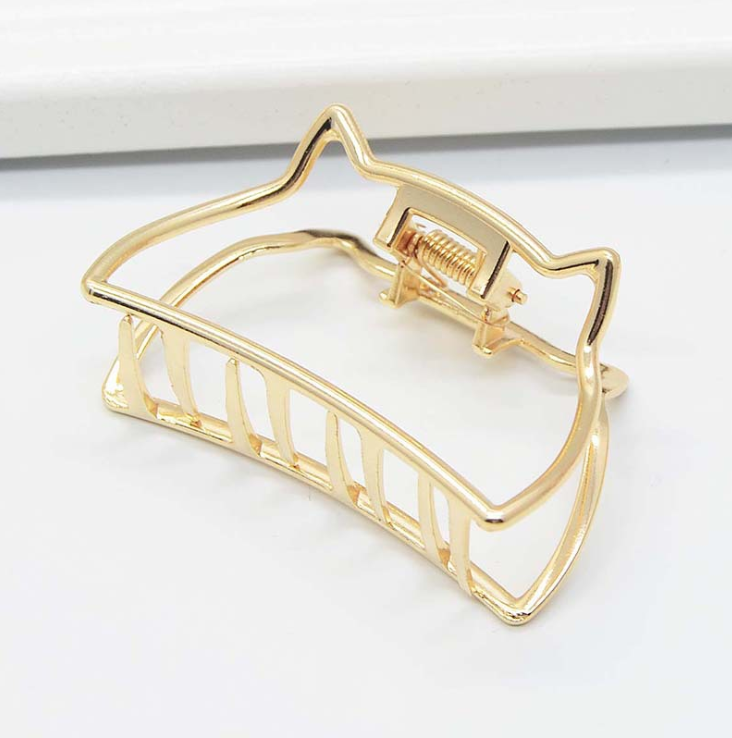 Gold-tone claw clip with a cat-ear outline along the top edge