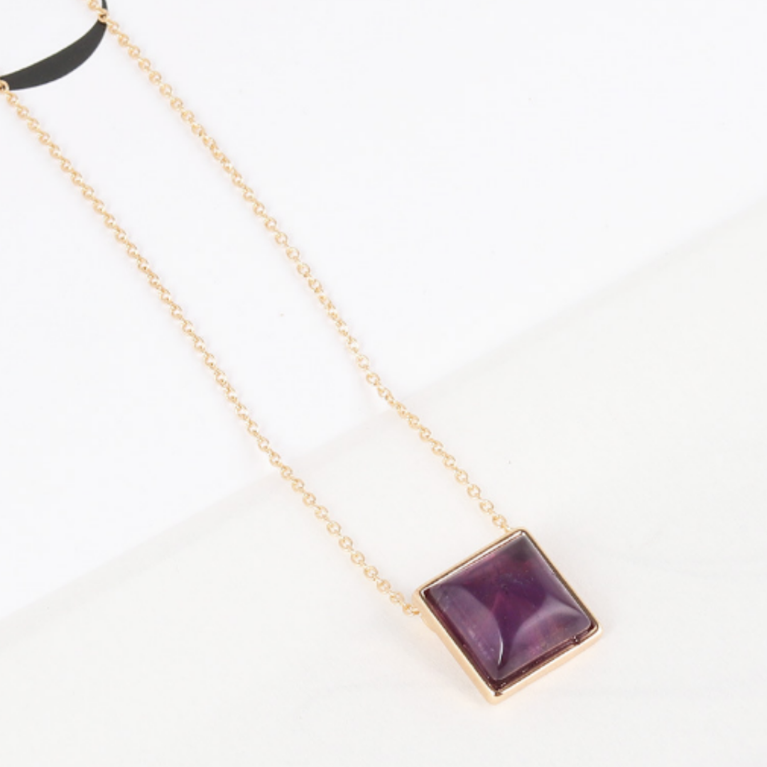Purple square pendant on a fine gold-tone chain, angled view
