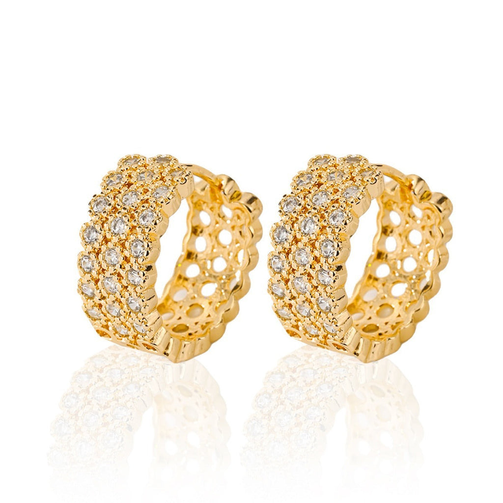 Pair of gold-tone huggie hoops with three rows of clear zircons and open-work sides, white background