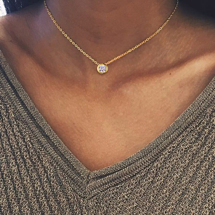 Gold-tone bezel zircon pendant necklace worn at the neckline