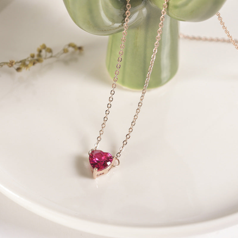 Deep pink heart-shaped pendant on a fine rose gold-tone chain, white dish