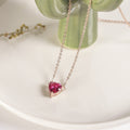 Deep pink heart-shaped pendant on a fine rose gold-tone chain, white dish