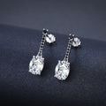 Silver-tone oval zircon bar drop earrings with tiny black stones on a dark background