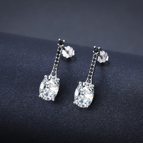Silver-tone oval zircon bar drop earrings with tiny black stones on a dark background