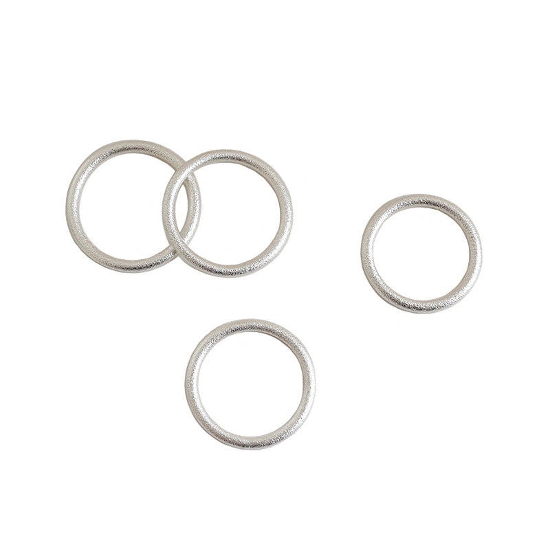 Four silver-tone textured stacking rings on a white background