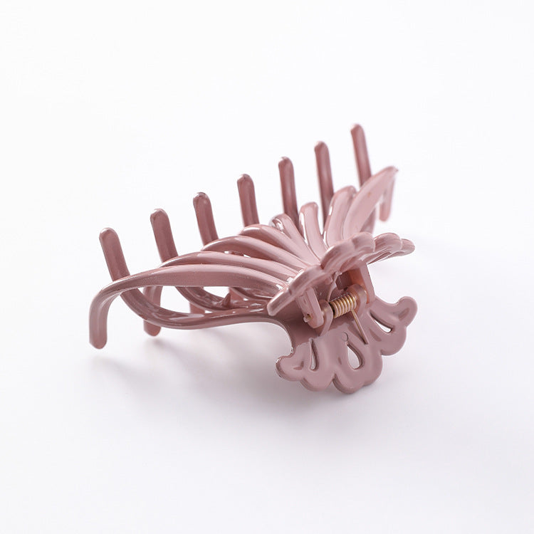 Dusty pink wave hair claw clip seen from the back on a white background