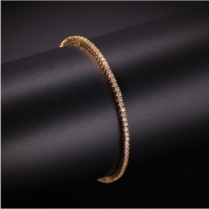 Gold-tone tennis bracelet set with zirconia stones on a dark tube