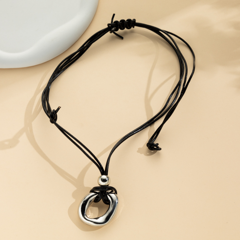 Silver-tone irregular circle pendant on a dark adjustable cord