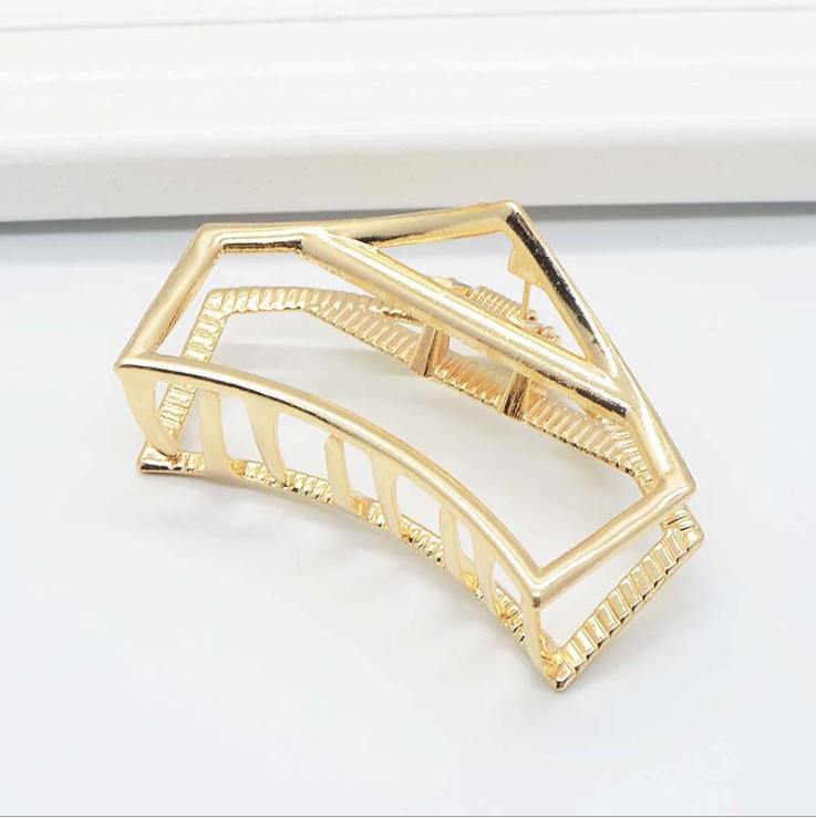 Gold-tone pentagon claw clip with an open five-sided frame