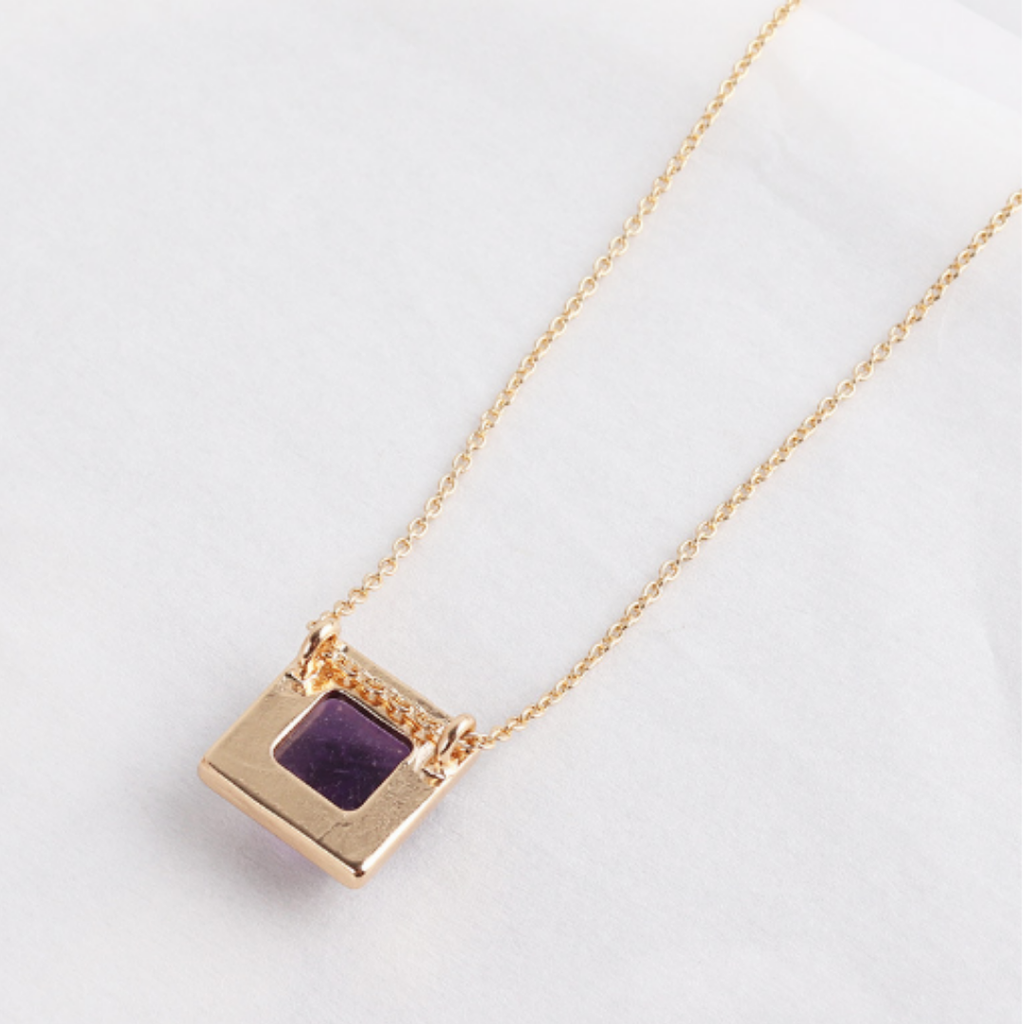 Back of the purple square pendant showing the open gold-tone frame and bail