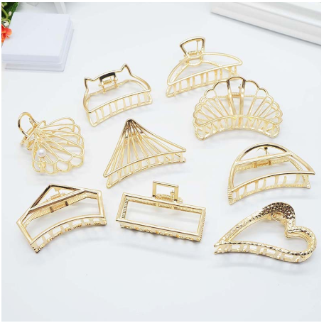 Nine gold-tone open-frame claw clips in different shapes, including heart, cat ears, rectangle and shell
