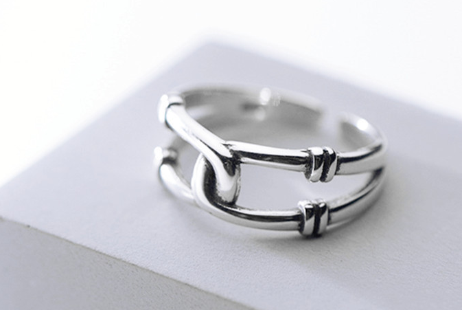 Silver-tone double band open ring on a grey block