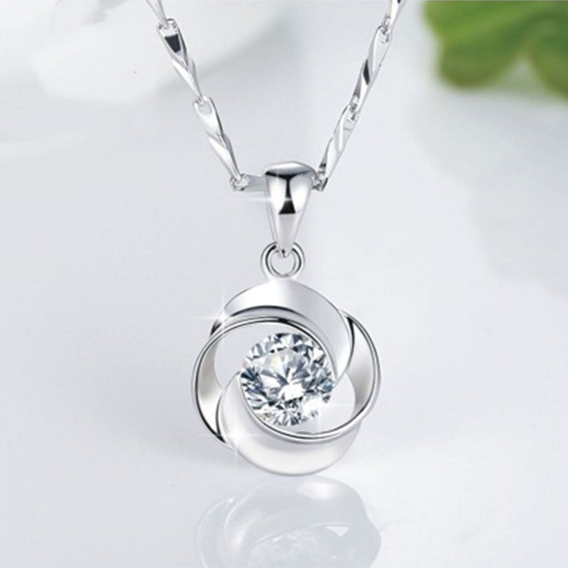 Swirl pendant set with a clear zircon on a silver-tone chain