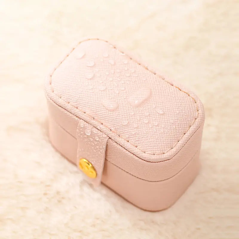 Closed pink mini ring travel case with a snap button