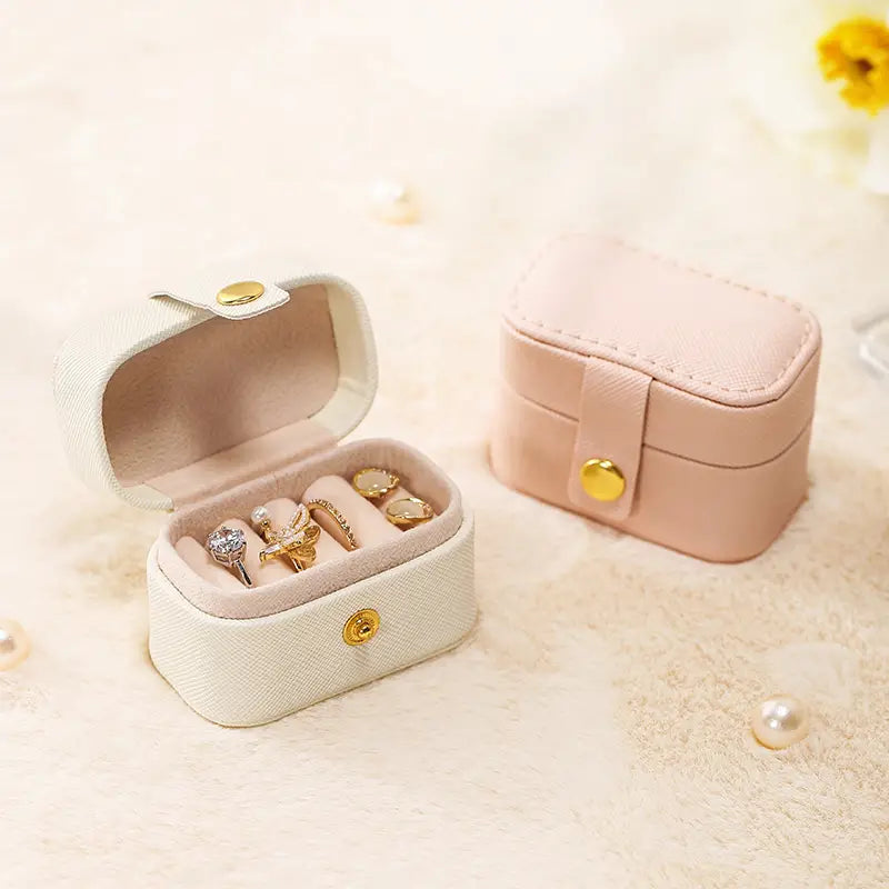 Cream and pink mini ring travel cases, one open with rings