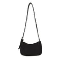 Black shoulder bag with a long eyelet strap and zip top, shown on a plain white background