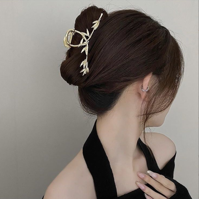 Gold-tone twig hair claw clip in a low bun