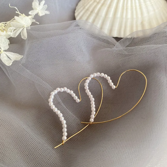 Pair of open heart hoop earrings made of pearl-style beads on a thin gold-tone wire