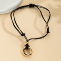 Gold-tone irregular circle pendant on a dark adjustable cord