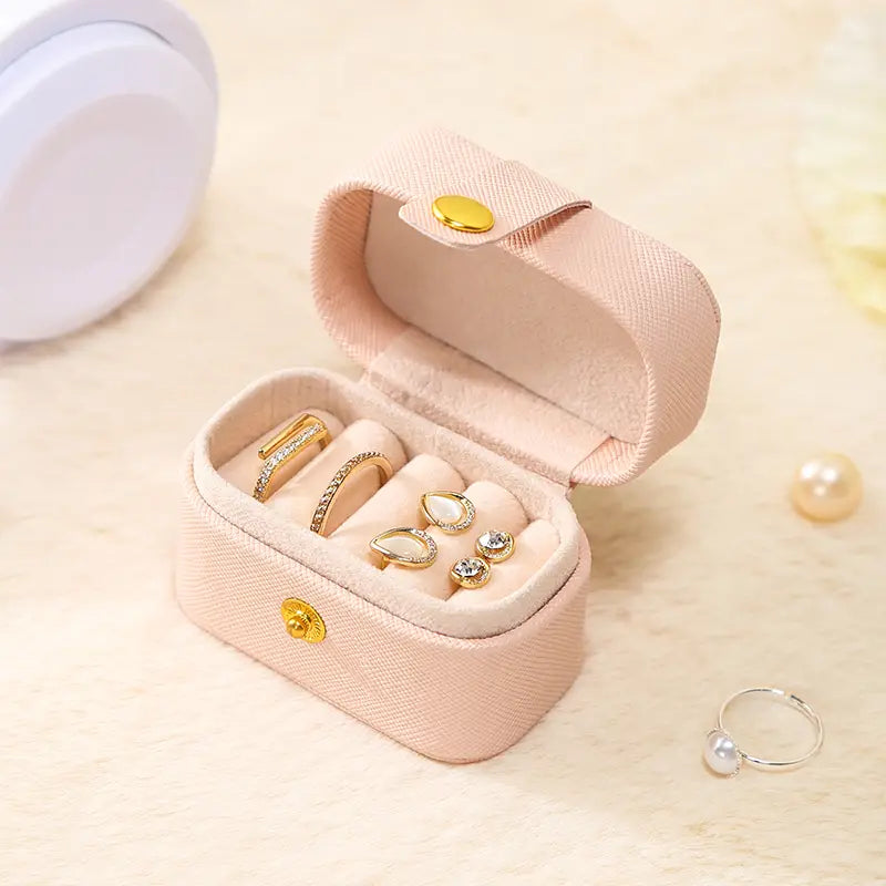 Pink mini ring travel case, open with gold-tone rings