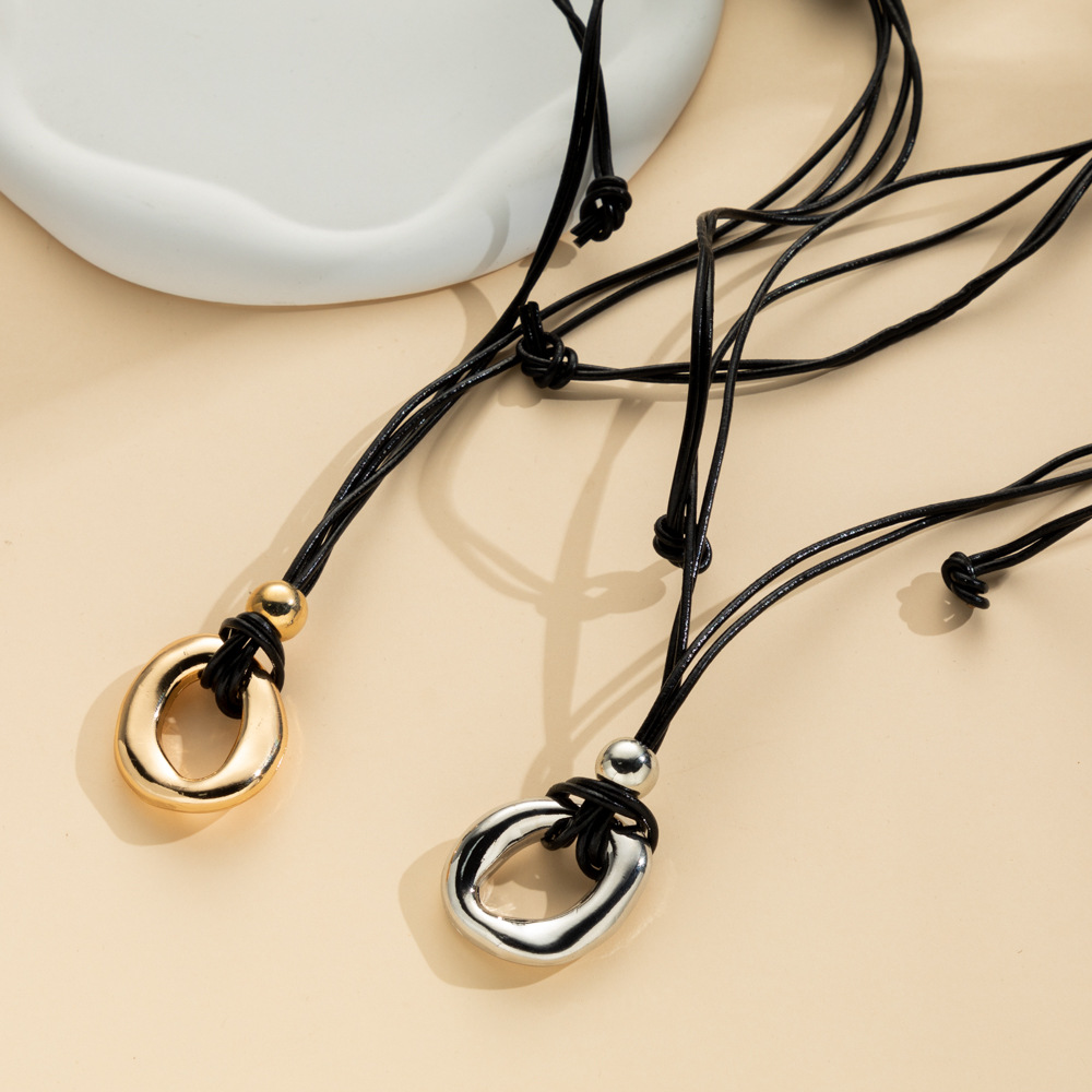Gold-tone and silver-tone irregular circle pendants on dark cords